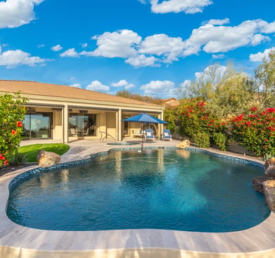 Scottsdale outdoor living area with pool, covered patio, and landscaped yard, offering comfortable indoor-outdoor flow.