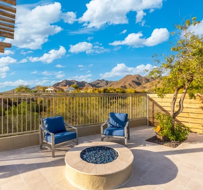 Cozy Scottsdale patio with fire pit and seating area overlooking scenic mountain views and desert landscape.