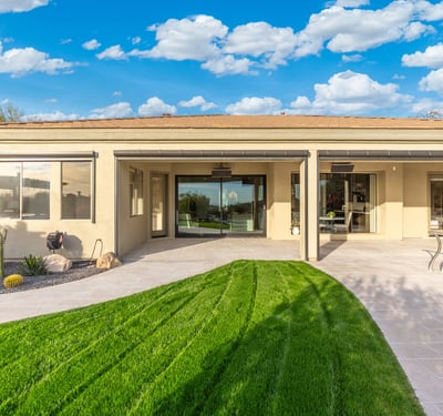 Scottsdale outdoor space with covered patio, green lawn, and sliding glass doors, creating seamless indoor-outdoor living.
