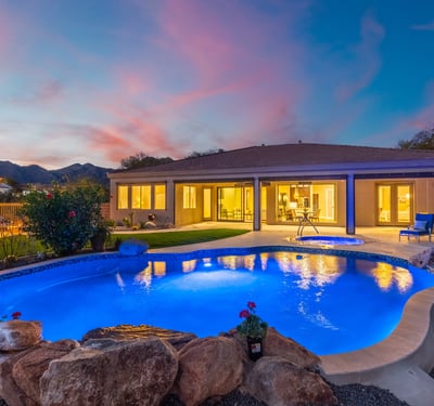 Scottsdale outdoor living at dusk with illuminated pool, spa, and patio, highlighting resort-style design and modern lighting.