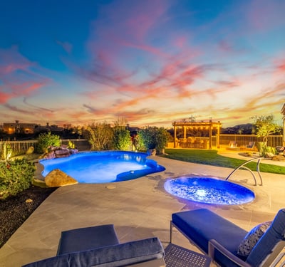 Scottsdale backyard with pool, pergola kitchen, fire pit, and sunset views, designed for upscale outdoor gatherings.