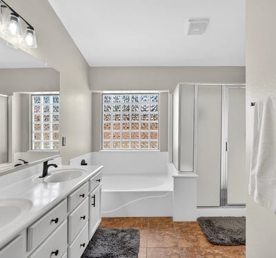 Bright primary bathroom with dual vanities, soaking tub, and walk-in shower. Functional layout offers everyday comfort in this Casa Grande property.