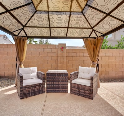 Backyard pergola with cozy seating creates a peaceful outdoor retreat. Perfect for relaxing near the pool in this Casa Grande home.