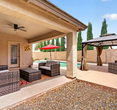 Covered patio with seating and views of the pool and pergola area. Designed for entertaining and enjoying Arizona-style outdoor living in Casa Grande.