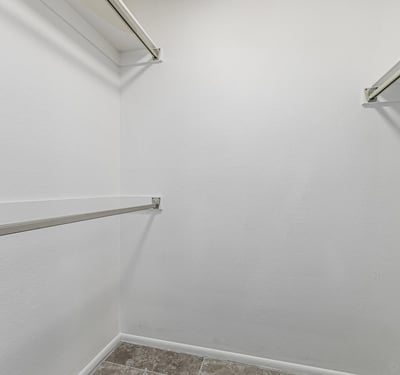 Generous walk-in closet with organized hanging space. This Sun City home includes practical storage and well-designed interiors.
