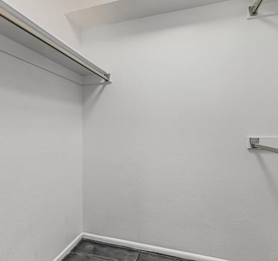 Well-sized walk-in closet with hanging rods and storage space. This Sun City home offers organized living and practical storage solutions.