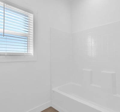 Bright full bathroom featuring a tub and shower combination, contemporary fixtures, and crisp finishes. Natural light and thoughtful design create a comfortable and welcoming space for residents and visitors.