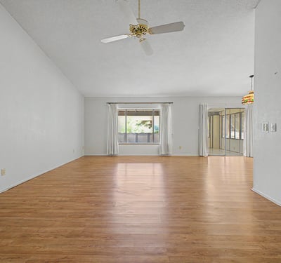 Designed for comfort and flexibility, this open living area features large windows, soaring ceilings, and abundant natural light. The layout seamlessly supports both everyday living and entertaining.
