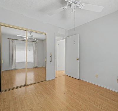 Mirrored closet doors and a generous floorplan make this secondary bedroom feel open and inviting. The adaptable space is well-suited for guests, family members, or a dedicated home office.