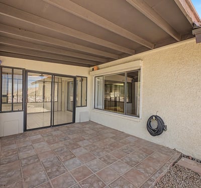 This covered patio provides a comfortable outdoor gathering space with direct access to the enclosed Arizona room. The low-maintenance design enhances everyday enjoyment and outdoor entertaining possibilities.
