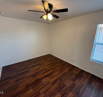 Bright and airy bedroom offering wood-look flooring, ceiling fan, and natural light. This versatile space works well as a guest room, home office, or primary sleeping area.