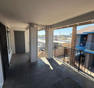 Second-level covered walkway with railings and open views overlooking the community grounds. This shaded exterior space enhances accessibility while contributing to the property's welcoming atmosphere.