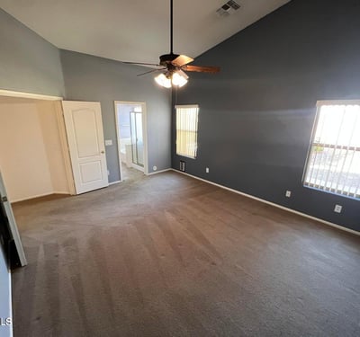 Comfortable primary bedroom featuring large windows, elevated ceilings, and generous square footage. A peaceful retreat designed to provide comfort and privacy.