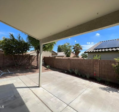 Covered patio offering shade and views of the landscaped backyard. The generous outdoor living area is ideal for entertaining, dining, or simply enjoying the peaceful surroundings of this Goodyear property.