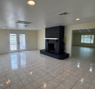 Inviting family room highlighted by a bold two-way fireplace, backyard access, and generous living space. The open design makes this area ideal for relaxing or hosting family and friends.