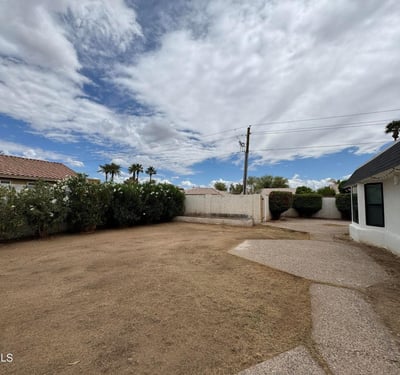 Attractive backyard retreat featuring mature landscaping, privacy fencing, and spacious grounds. The combination of patio surfaces and open yard space creates excellent potential for outdoor enjoyment and entertaining.