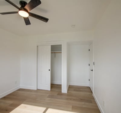 Updated flooring, fresh paint, ceiling fan, and a spacious closet make this bright bedroom an excellent option for family, guests, or flexible living space.