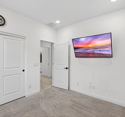 This comfortable secondary bedroom offers soft carpeting, neutral finishes, recessed lighting, and flexible space suitable for guests, children, or a private office in Surprise.