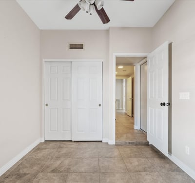 Featuring tile flooring, ceiling fan, and generous closet storage, this flexible bedroom easily accommodates guests, family, or a productive home office.