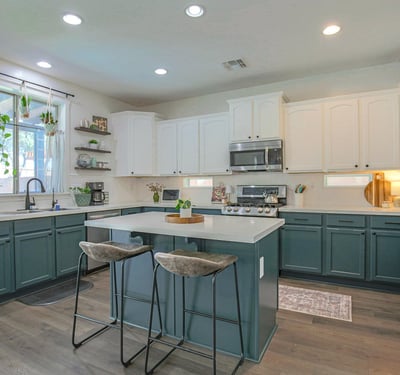 Elegant kitchen featuring quartz countertops, custom-painted cabinetry, stainless steel appliances, and a spacious island with seating. A beautifully updated centerpiece for this move-in-ready Waddell home.