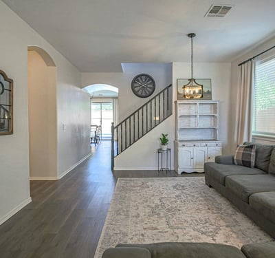 Comfortable living room with updated flooring, elegant lighting, and an open floor plan that creates a warm and welcoming atmosphere for everyday living and entertaining.