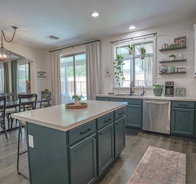 Beautifully updated kitchen featuring abundant cabinetry, quartz countertops, stainless steel appliances, and an open layout connecting effortlessly to the dining room and outdoor living areas.