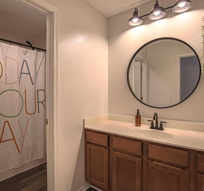 Bright secondary bedroom with plush carpeting, ceiling fan, generous natural light, and space for a desk or workspace. A versatile room perfect for family, guests, students, or working from home.