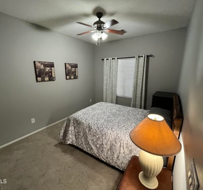 Secondary bedroom with neutral d cor, ceiling fan, and ample floor space, offering flexibility for guests, a home office, or a hobby room.