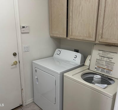 Enjoy the convenience of a dedicated laundry room complete with washer, dryer, built-in cabinetry, and practical storage to simplify daily routines.