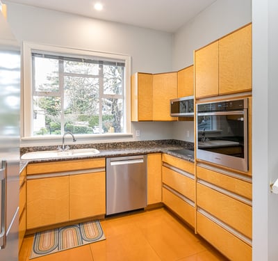 Bright and modern kitchen featuring ample storage, sleek appliances, and a view of the landscaped garden.