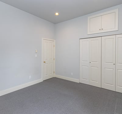Spacious room with ample natural light, featuring dual closets and a versatile layout for various uses.