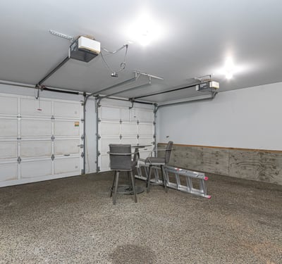 Spacious garage with ample room for storage, featuring high ceilings and convenient overhead lighting.