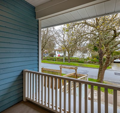 Enjoy morning coffee on this inviting porch overlooking a tree-lined street in a peaceful neighborhood.