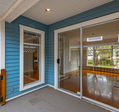 Bright, inviting entryway with large glass doors leading to a spacious, light-filled living area.