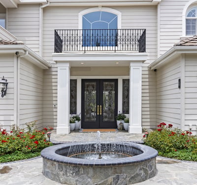 Elegant private entryway features a tranquil fountain and landscaped gardens, creating an inviting first impression.