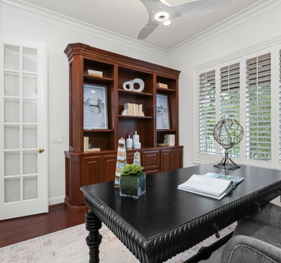 Home office featuring built-in shelving, large windows, and modern lighting for productivity.