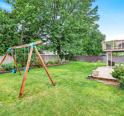 Spacious yard with swing set charm.
