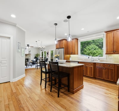 Modern kitchen with spacious island, abundant natural light, and rich wood cabinetry, perfect for entertaining.