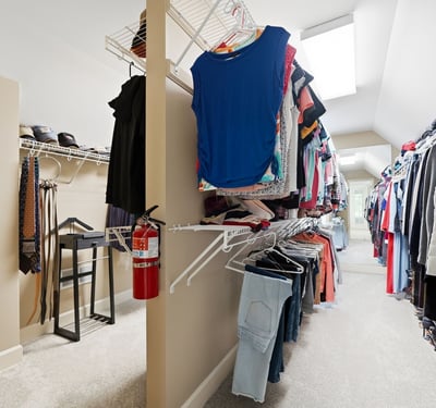 Spacious walk-in closet featuring abundant shelving for organized storage and natural light from skylights.