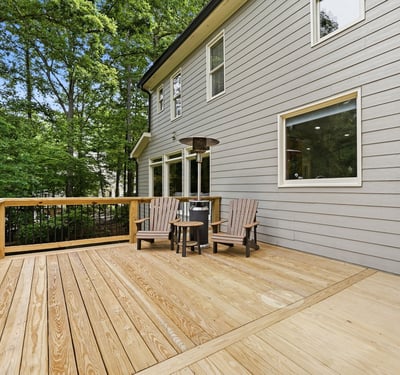 Spacious outdoor deck surrounded by trees, perfect for relaxing or entertaining in a private setting.