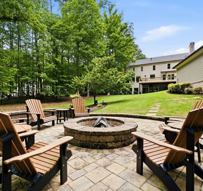 Gather around the fire pit in this spacious backyard, nestled among lush greenery and nature.