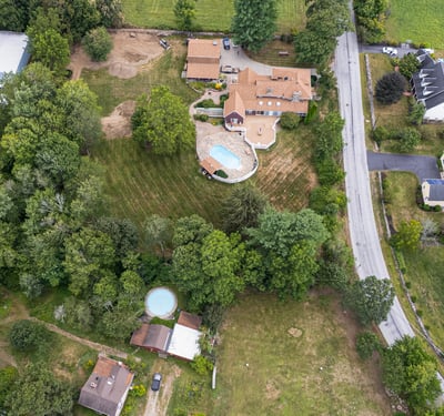 Spacious property with multiple buildings, expansive lawns, and a pool, situated near scenic landscapes and easy access roads.