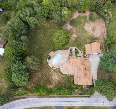 Spacious property featuring a pool, expansive lawn, and potential for development in a quiet neighborhood.
