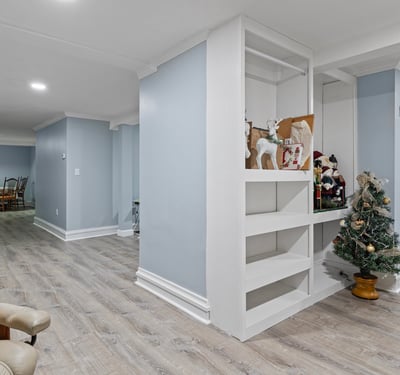 Bright and spacious basement with versatile layout, featuring built-in shelving and ample room for activities.