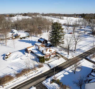 Spacious homes on expansive snowy lots, surrounded by trees and tranquil countryside views, perfect for peaceful living.