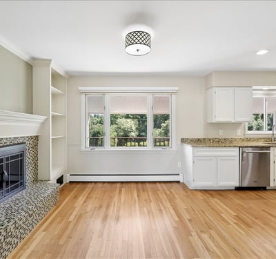 This inviting space features a modern kitchen, cozy fireplace, and abundant natural light overlooking the backyard.