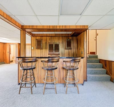 Spacious lower level featuring a cozy bar area and ample natural light throughout.