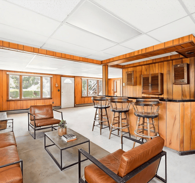 Spacious living area features a bar and ample natural light, perfect for entertaining or relaxing.