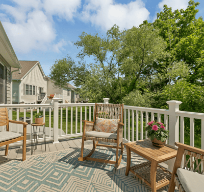 Relax on this inviting deck, surrounded by lush greenery and featuring comfortable seating for outdoor enjoyment.