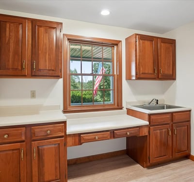 Bright kitchen space featuring ample cabinetry, a large window with outdoor views, and efficient countertop area.